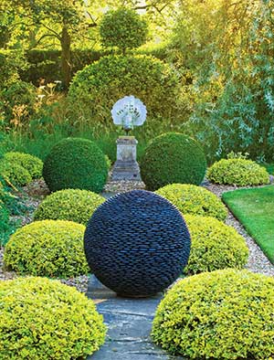 Dark Planet sphere on a path between topiary balls
