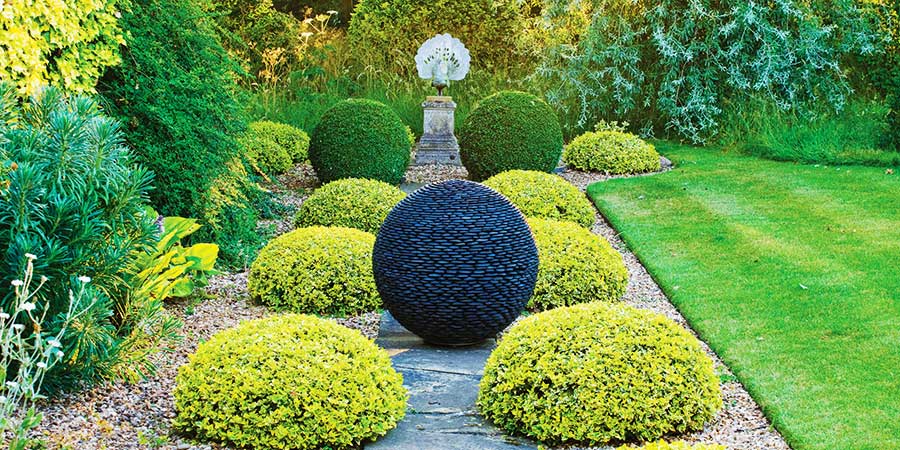 Dark Planet stone sphere in a garden