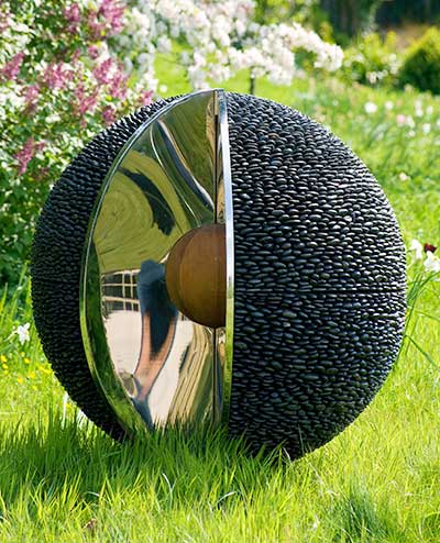 Esfera de piedra para jardines que presenta un corte en forma de cuña