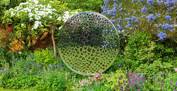 Sculpture made from two parallel circular discs with laser cut patterns that plays with light and shade