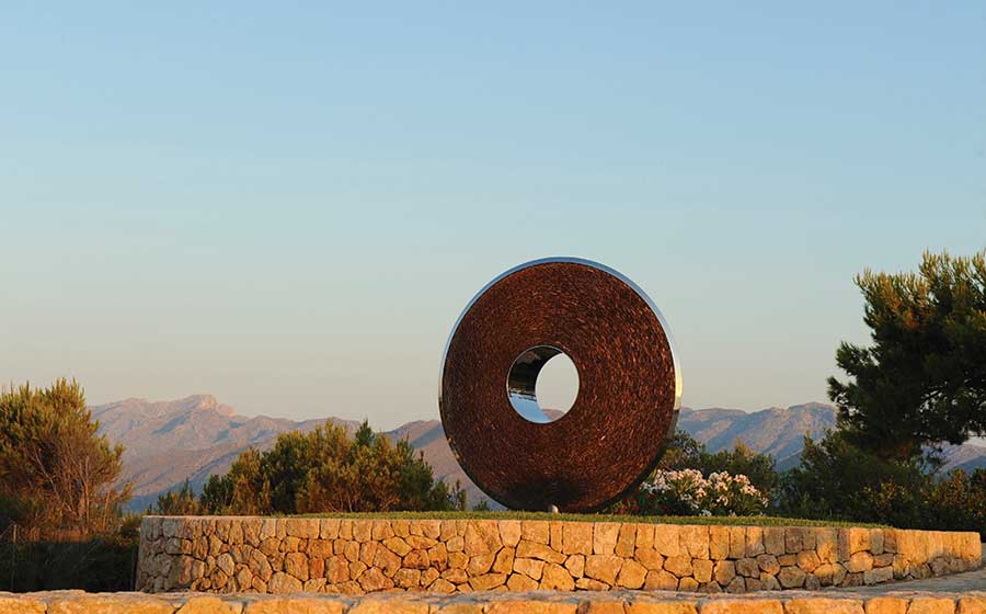 Sculpture Torus en ardoise et en acier installée dans le paysage Majorque.
