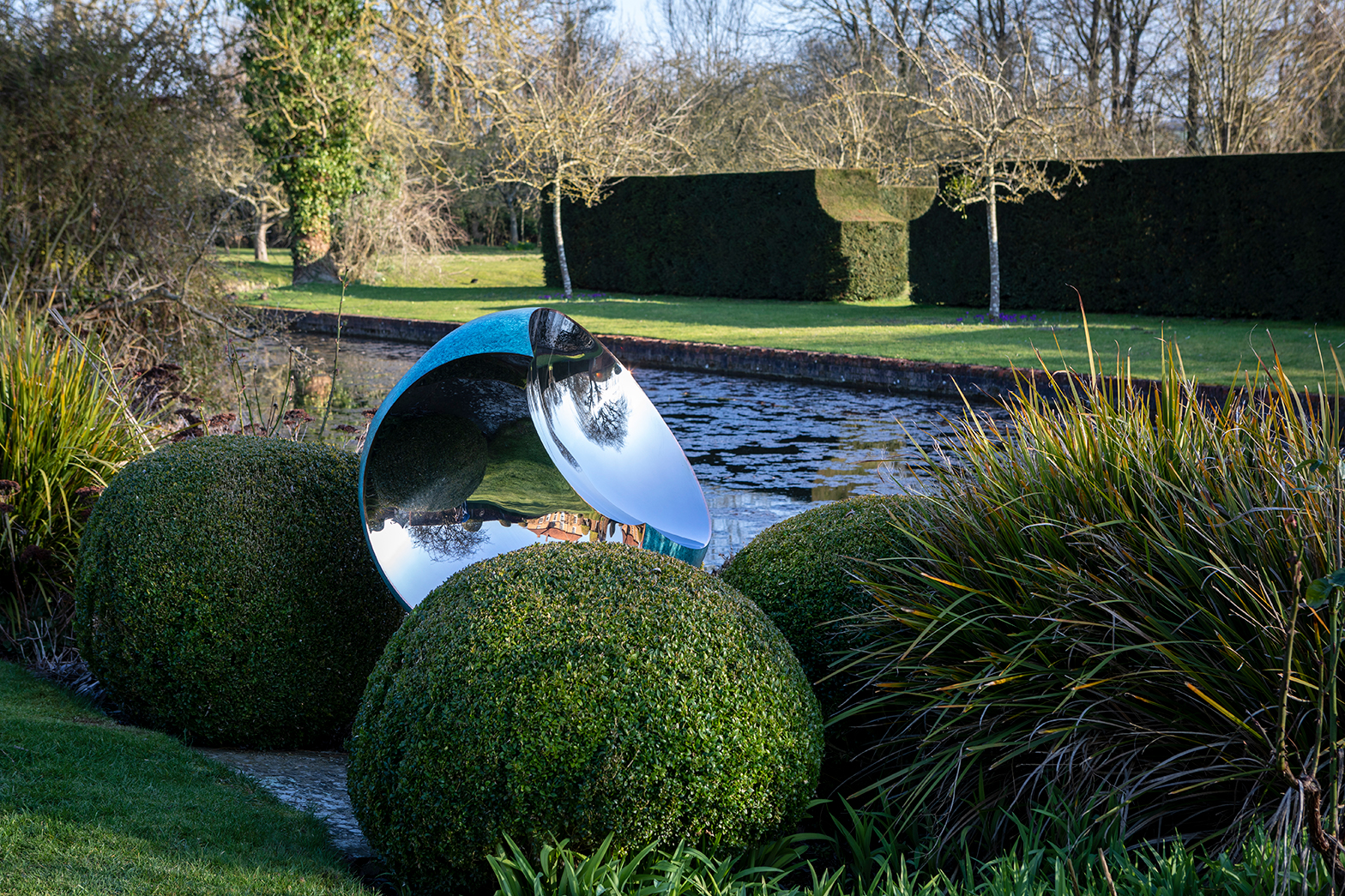 Bite copper sculpture in a traditional English garden