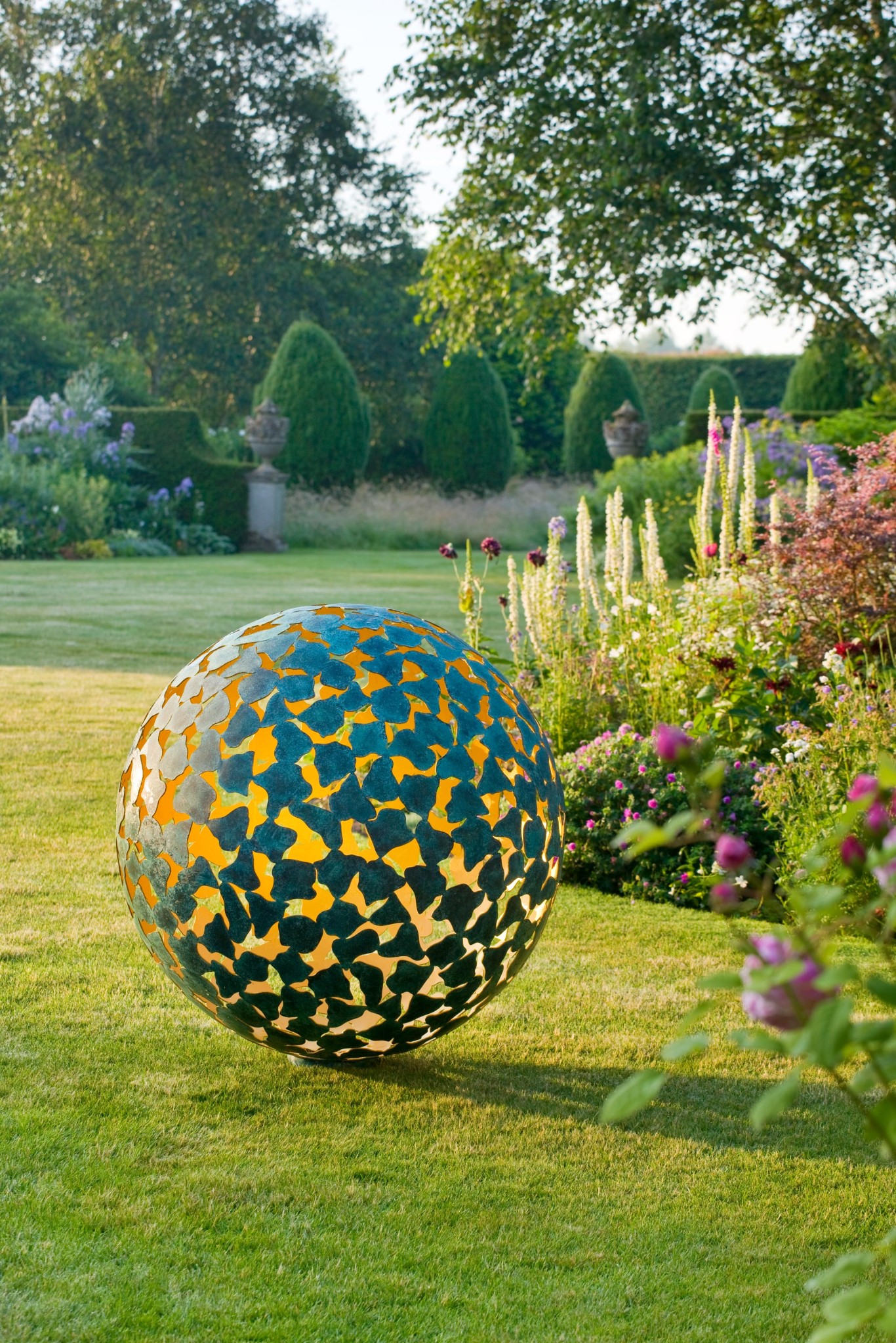 Dark Planet sphere on a path between topiary balls