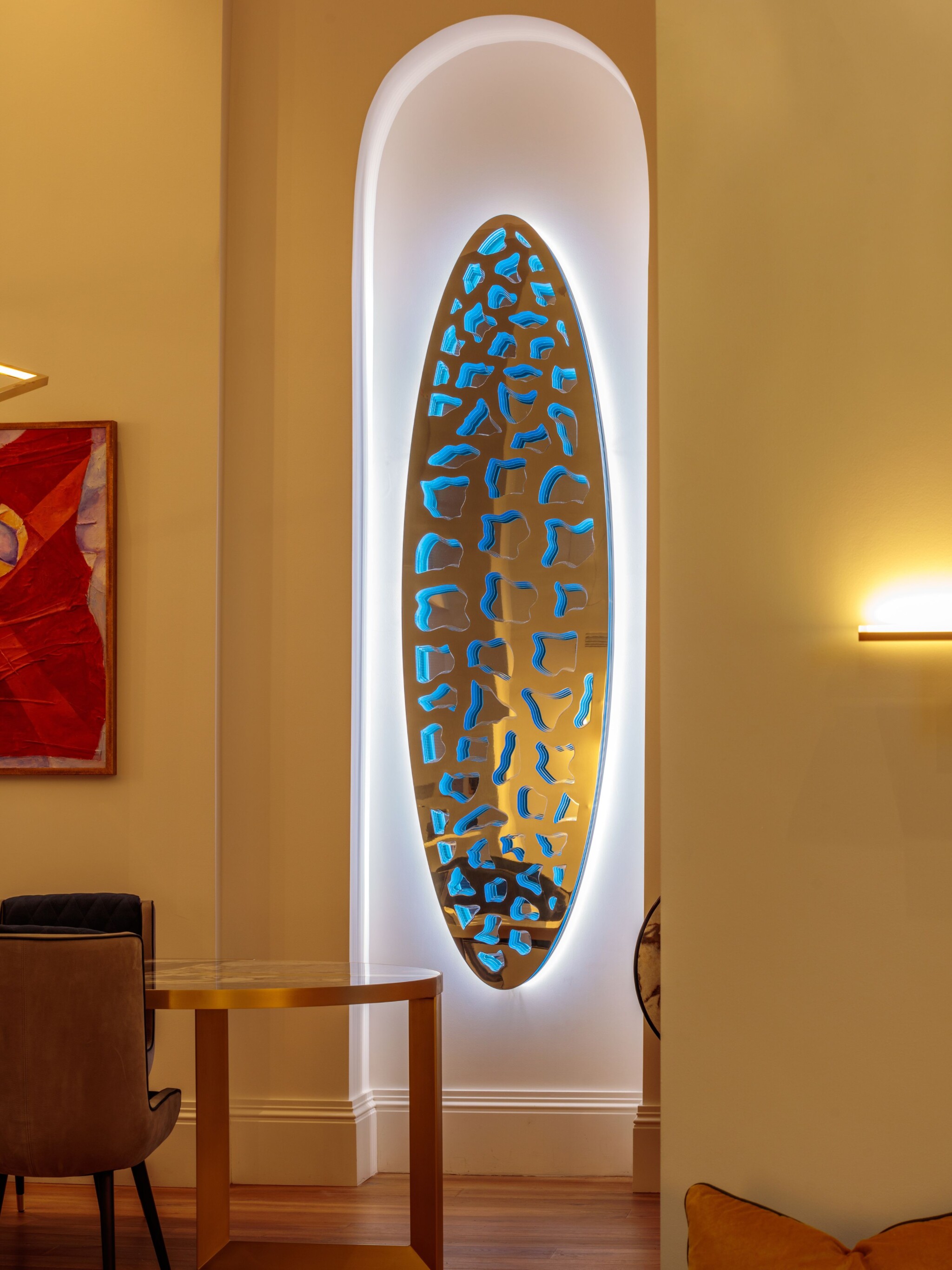 Patterned stainless-steel wall art backed with LED lights.