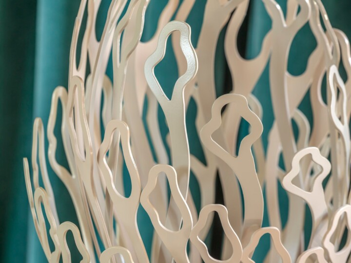 Alba oxidised steel abstract sculpture with organic, wavy cutouts set against teal and brown backgrounds.