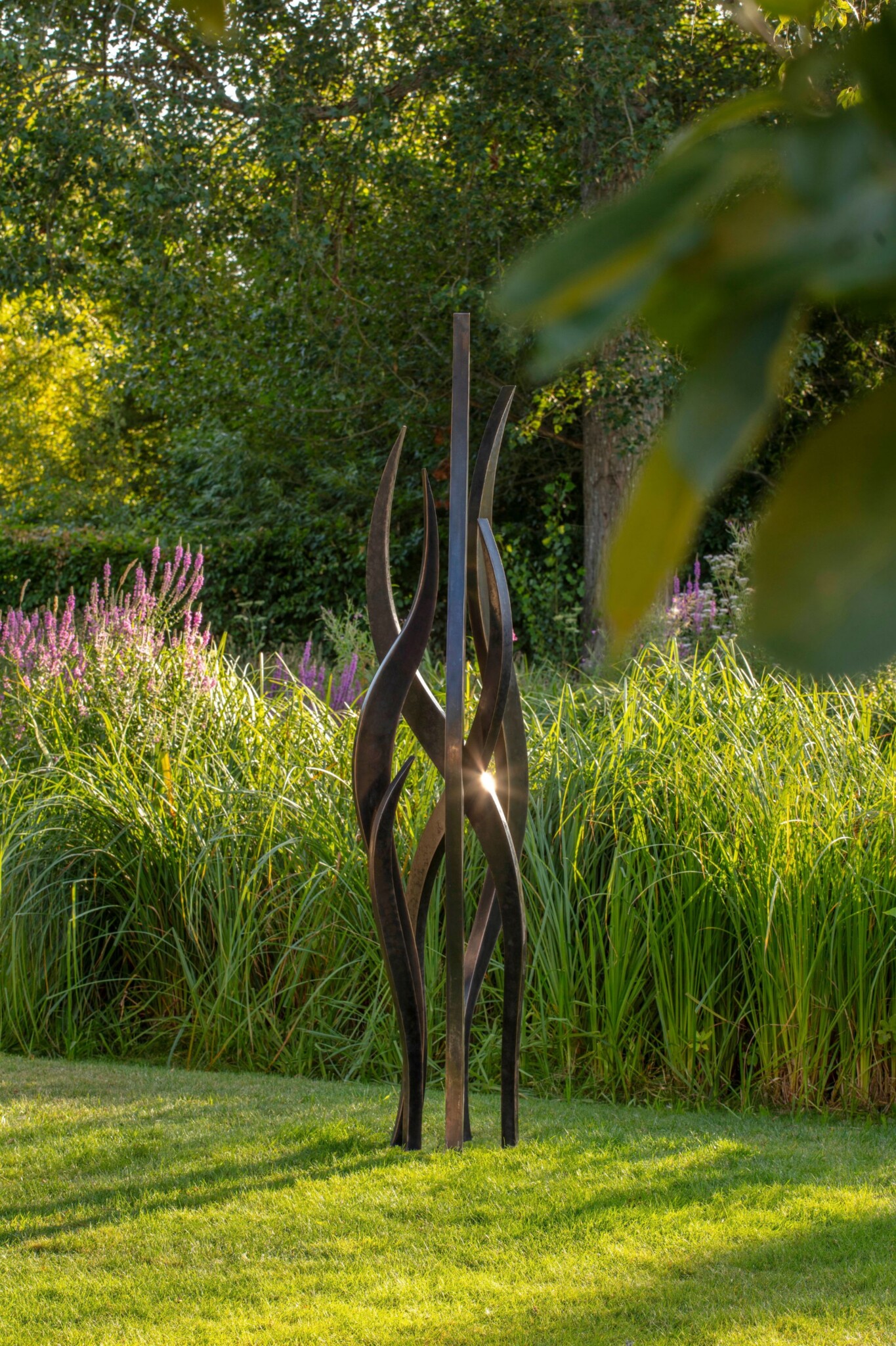 Light shines on a black garden sculpture