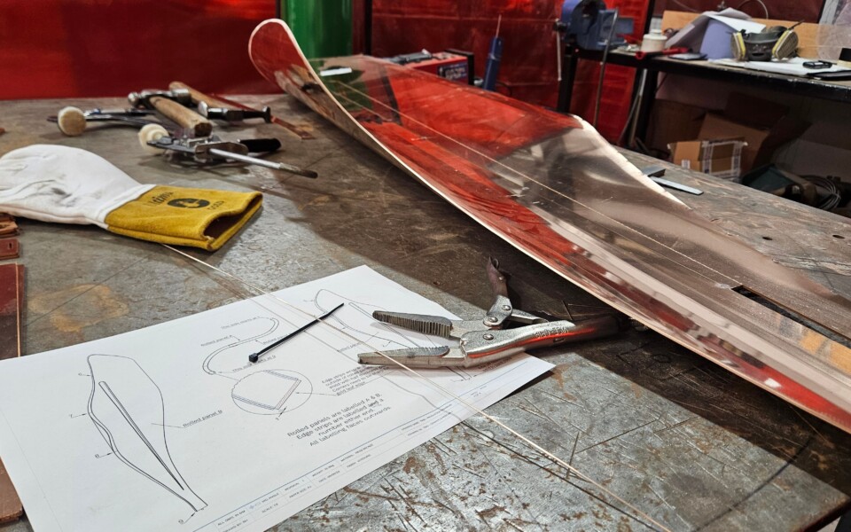 Scaled drawing on workshop bench with tools and first iteration of new sculpture