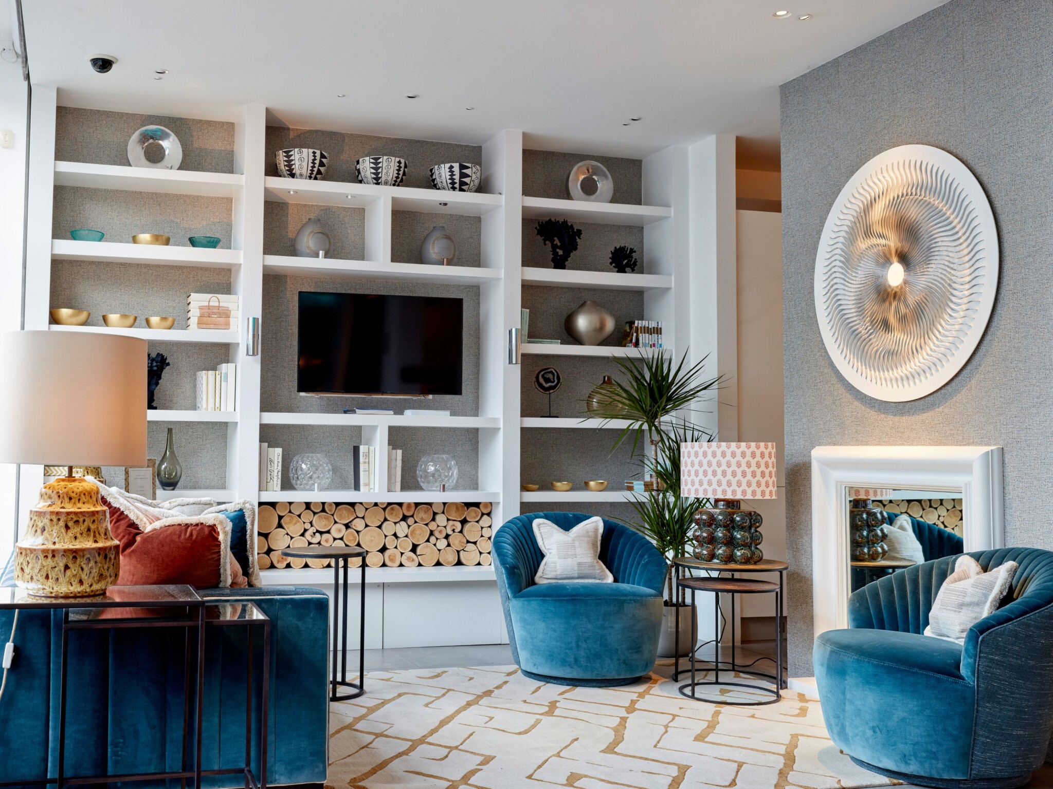 A luxurious living room with a striking piece of illuminated metal wall art above the fireplace