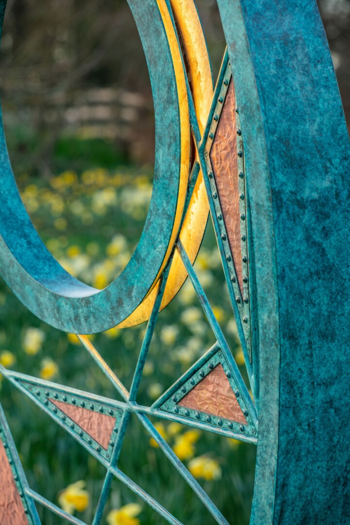 Multi-layered textures of patinated bronze and crumpled copper mesh link into a central void illuminated by a built in light