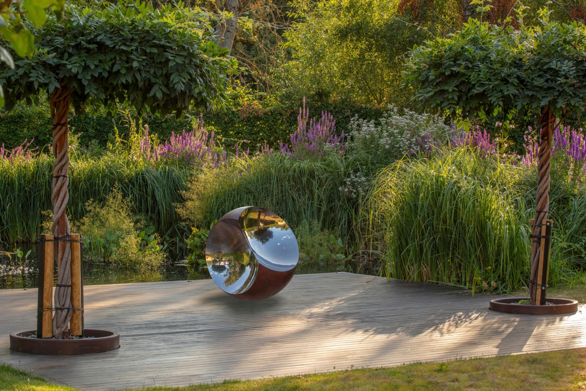 Sphere sculpture reflecting light and planting on a smart garden deck