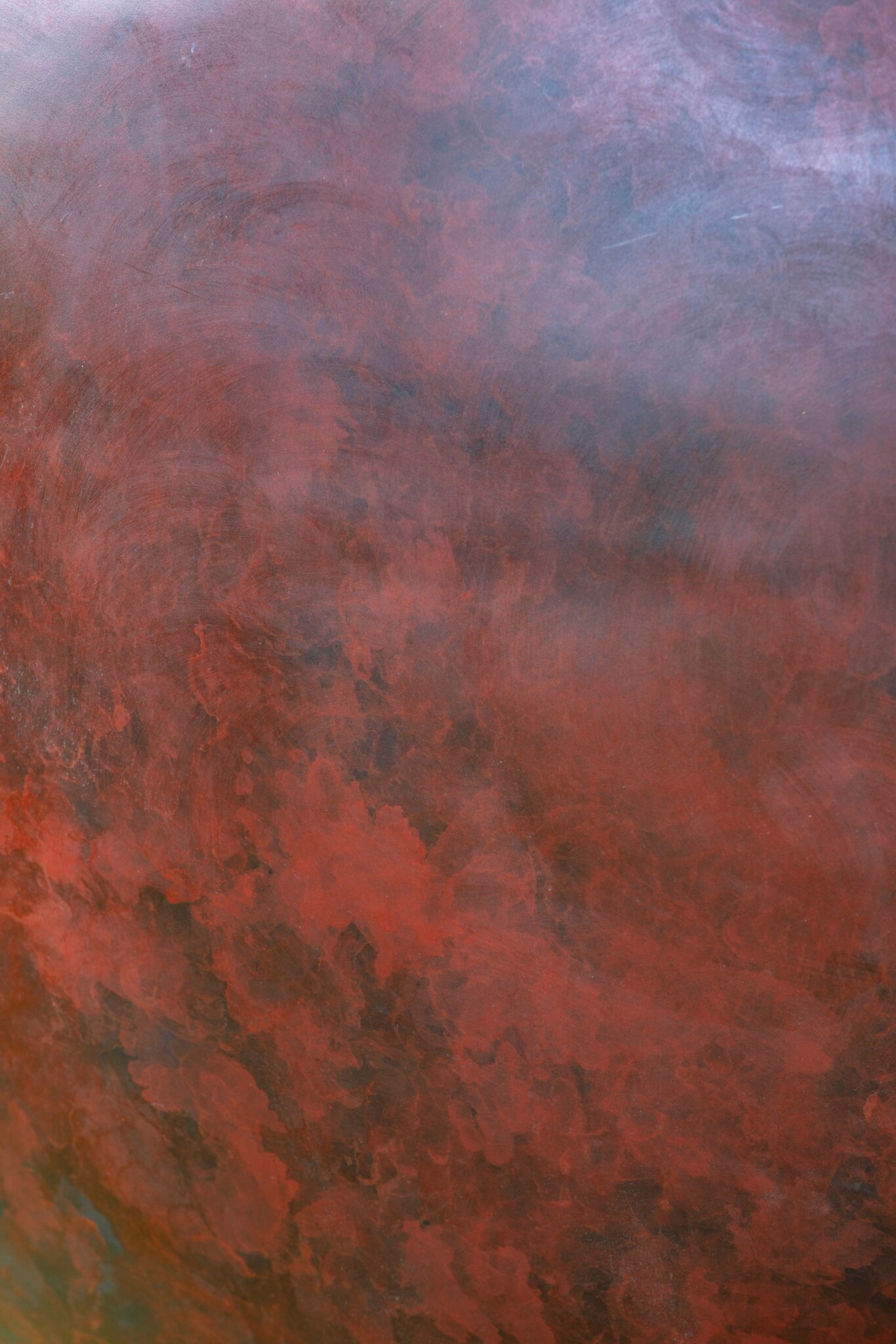 Close up of a red patina on a copper sculpture