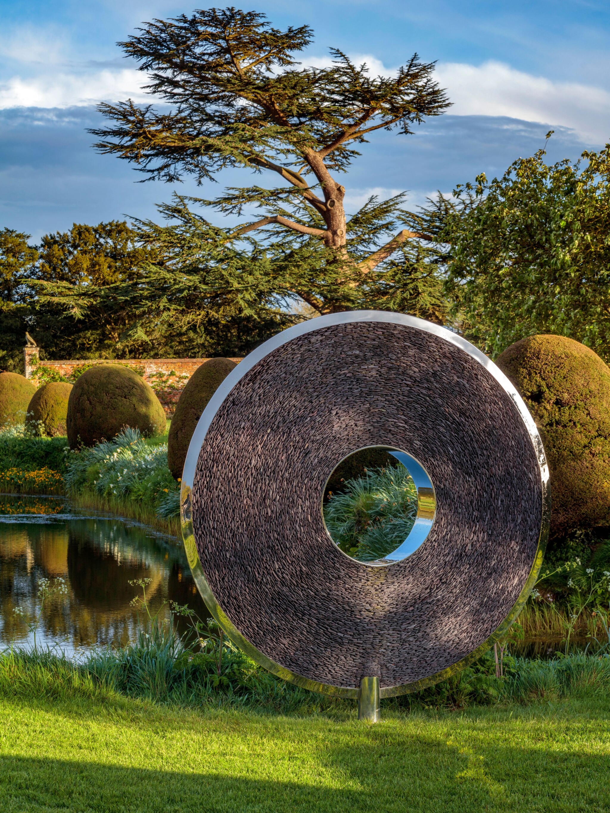 Slate and stainless-steel torus in garden setting