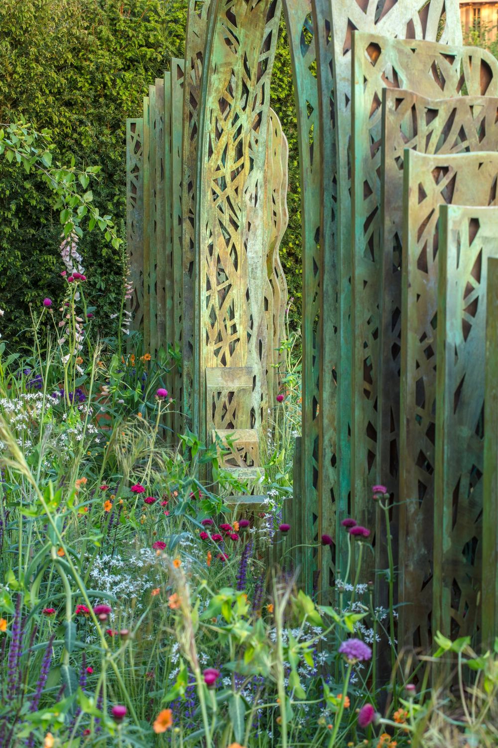 striking metal reed and water feature sculptures amidst wild, naturalistic planting