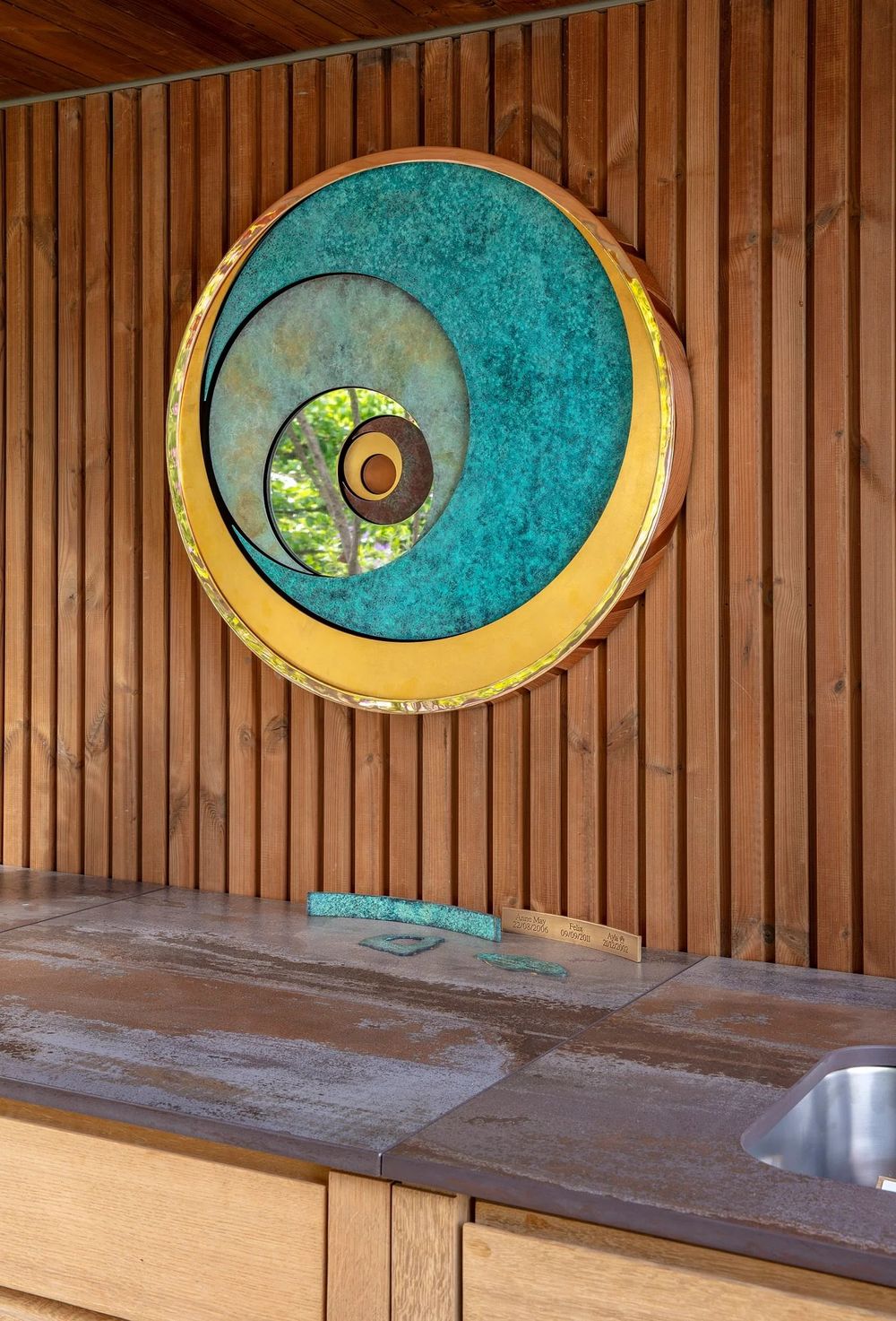 limited-edition Cosmos art piece featuring a vibrant, multi-layered turquoise and bronze circular design inspired by ancient astronomy