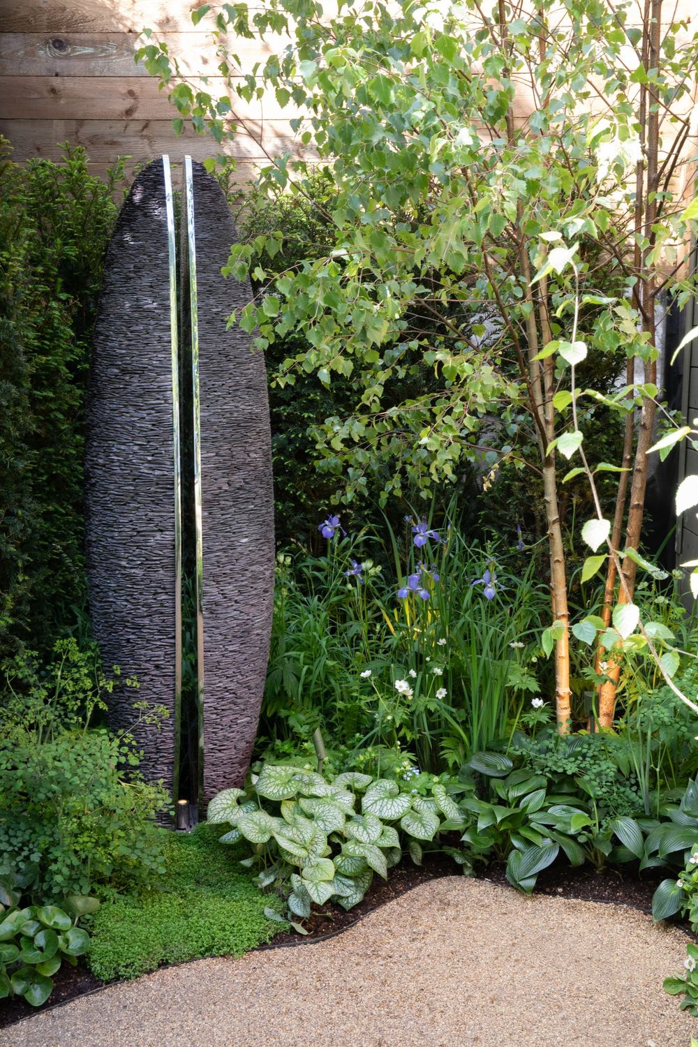 Slate Sentinel garden sculpture by David Harber, crafted from stacked Welsh slate with a split vertical mirrored stainless steel interior