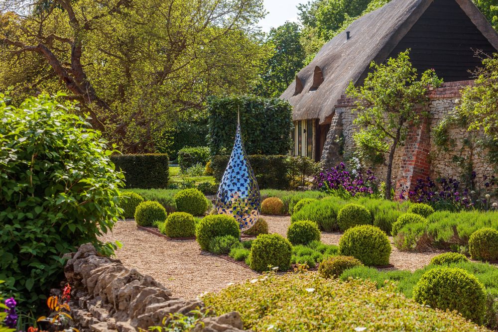 structured, formal layout with low, rounded evergreen shrubs arranged symmetrically along an earthen pathway